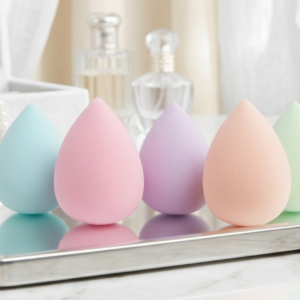 Five colorful teardrop makeup sponges in pink, blue, purple, peach, and green on a silver tray