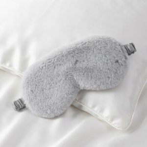 Grey luxury faux fur sleep mask with satin lining on white background