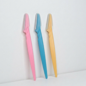 Set of 3 pastel-colored eyebrow razors with clear plastic safety covers