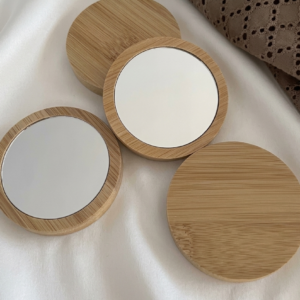 Round 7cm natural wood pocket mirror on white fabric background